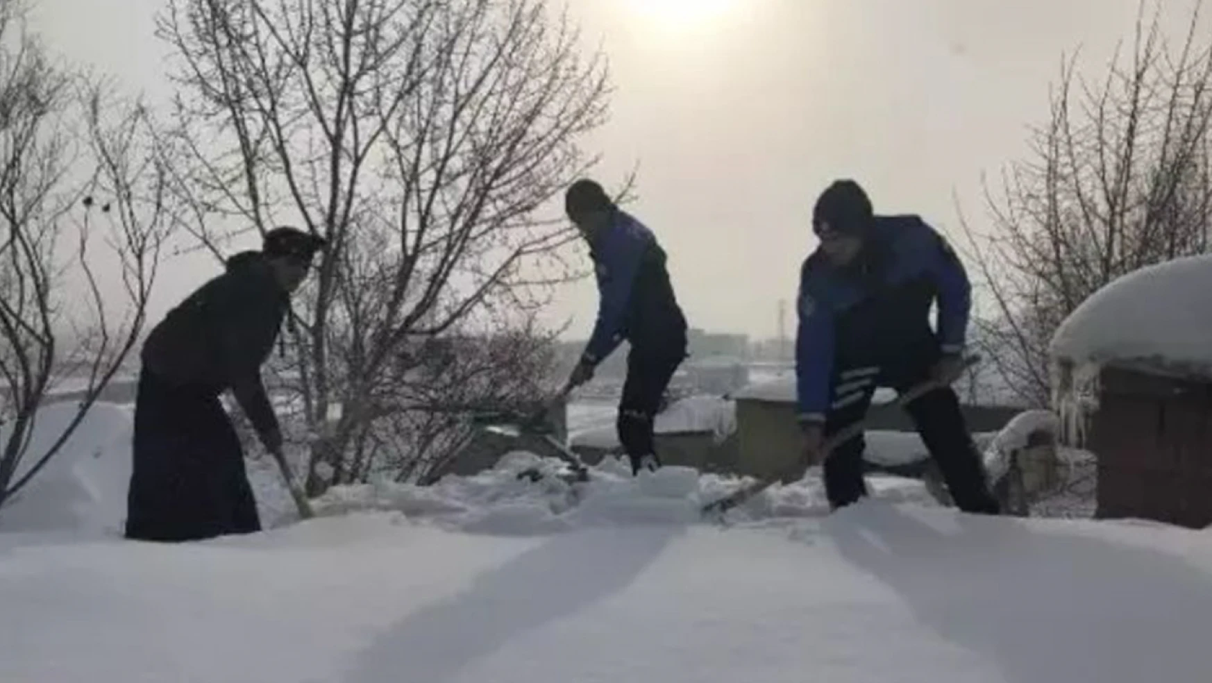 Toprak evinin damını kardan temizlemeye çalışan kadına, polis memurları yardım etti