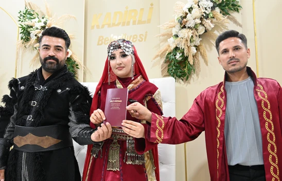 Bir çift nikah masasına geleneksel kıyafetlerle oturdu