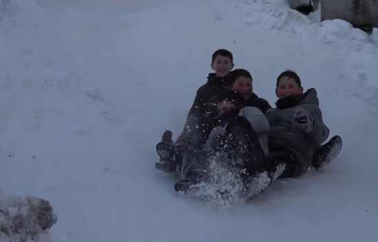Mahalle yolunu kızak pistine çeviren çocuklar doyasıya eğlendi