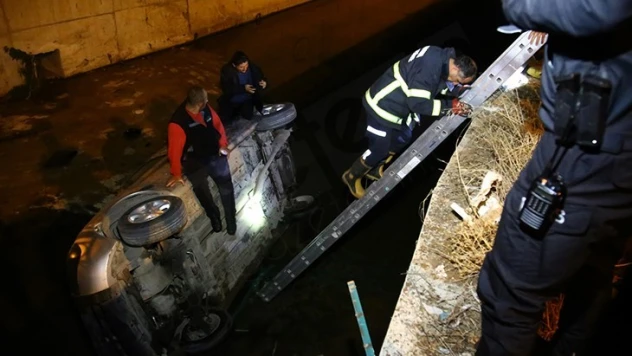Dere yatağına düşen aracın üstünde kurtarılmayı beklediler