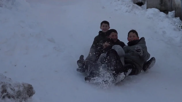 Mahalle yolunu kızak pistine çeviren çocuklar doyasıya eğlendi