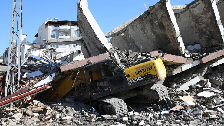 Ağır hasarlı bina yıkım sırasında iş makinesinin üzerine çöktü