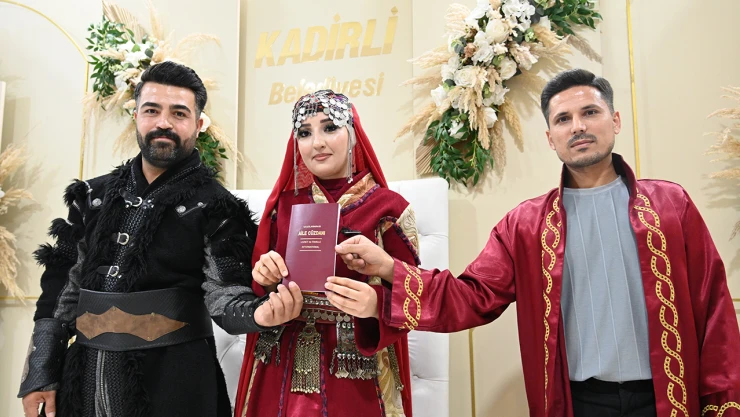 Bir çift nikah masasına geleneksel kıyafetlerle oturdu