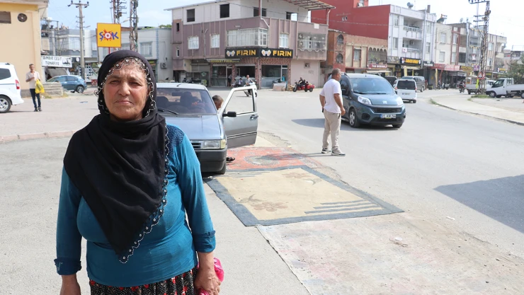 Tozdan rahatsız olan kadın yoldaki çukurları halıyla kapattı